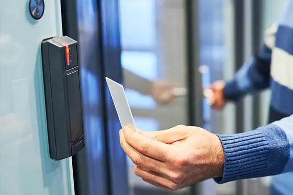 Hand holding a key card to an access-control reader