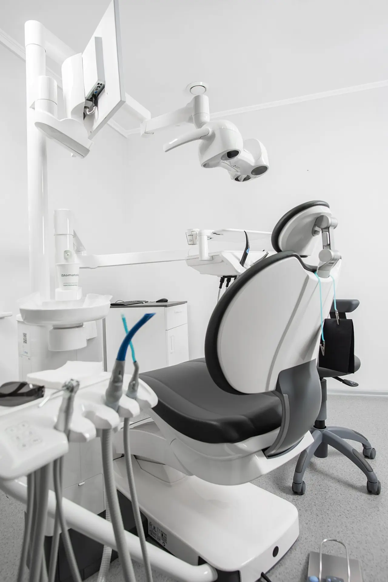 Dental treatment unit with patient chair, operating light and monitor in a clinic